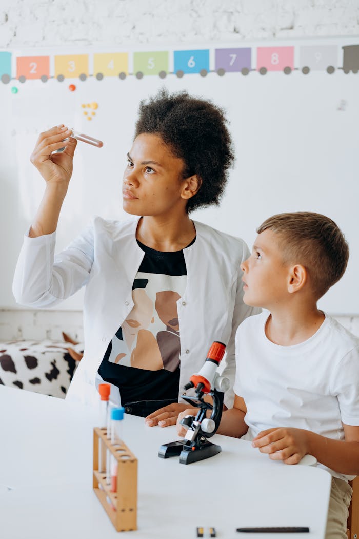 Teacher and student examine test tube in science class.
