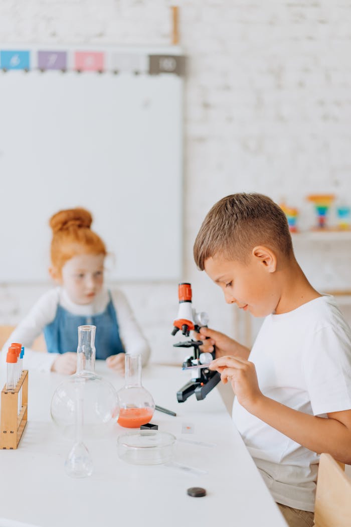 Young children engaging in a science experiment with lab equipment in a classroom setting.